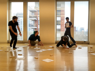 Photo of a rehearsal of the rite of computing in process: People dance with the shapes and objects according to the current choreographic configuration.