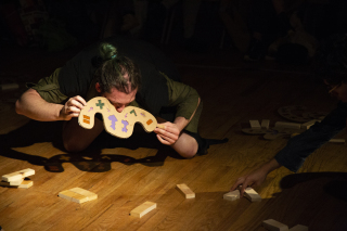 photo of a person with a symbol of cardboard in the face, while looking at pieces of wood in the floor
