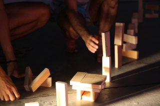 foto de piezas de madera en el suelo, con algunas manos manipulándolas